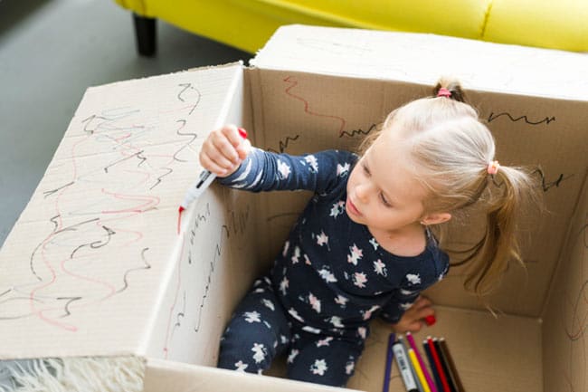 Kid painting inside a cardboard box